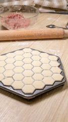 Hexagonal dumplings poised for creation, evoking Slavic kitchen tales, Lunar New Year delicacies,...