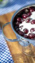 Glistening cherries dance under a sugar snow in steel embrace, capturing summer harvest and Cherry Pie Day magic
