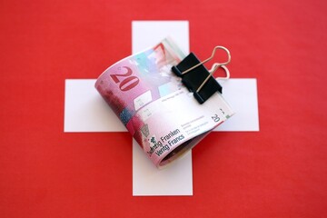 Swiss franc banknotes and flag. The francs money bills lies on flag in big amount
