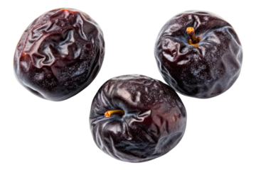 Three dried prunes with wrinkled skin isolated with transparent background