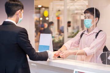 Cashier staff wears protective mask is withdrawing money to customers. New normal or New norm...