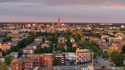 Cremona cityscape revealing historic Torrazzo bell tower, residential zones, and winding road under...