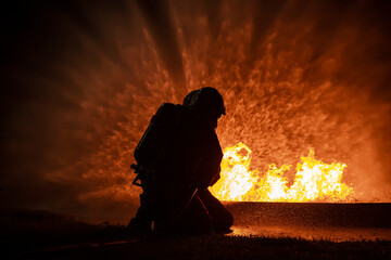 Firefighter training, fireman using water and extinguisher to fighting with fire flame in an...