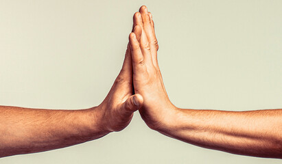 Two hands giving high five to each other, isolated on gray background. Two hands gestures. Giving...