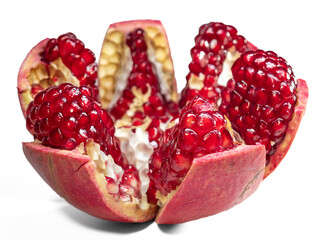 Juicy pomegranate fruit cut into pieces on a white background, pomegranate seeds isolated