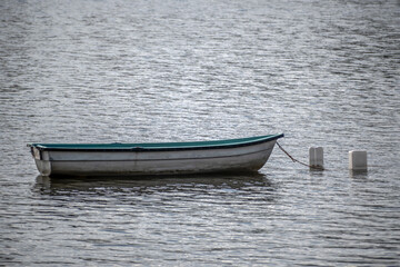An empty rowing boat at anchor on a summer day