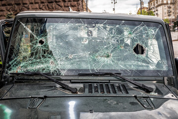 Holes on the windshield of the car. Bullet holes. Smash car windshield, broken and damaged car. The...