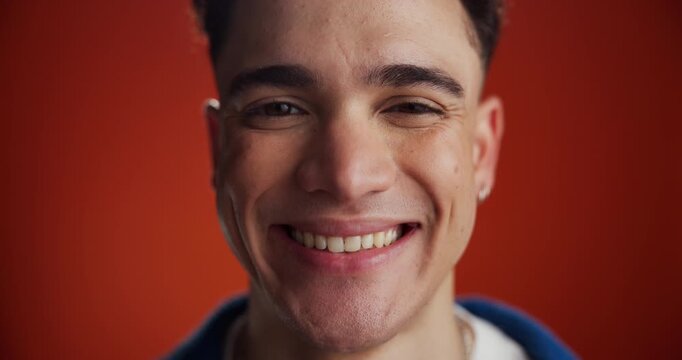 Man, face and laugh in studio, happy and confidence for pride with space on red background. Gen z person, smile and excited in portrait with expression, funny joke or emotion with humor in Costa Rica
