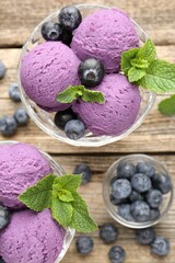 Tasty sorbet with blueberries and mint in dessert bowls on wooden table, flat lay