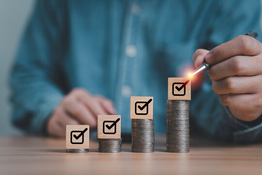 Businessman tick correct sign mark on the top of increasing coins stacking for financial approve concept.