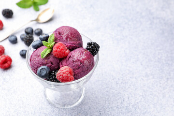 Delicious sorbet with fresh berries and mint in dessert bowl on grey textured table, closeup. Space for text