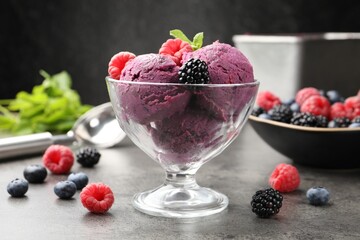 Delicious sorbet with fresh berries and mint in dessert bowl on grey textured table against dark background, closeup