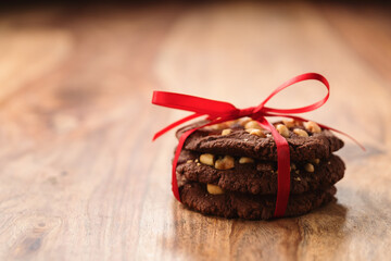 homemade chocolate cookies with hazelnuts tied with ribbon on wood table