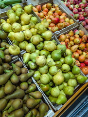 Fresh pears and apples displayed in wooden crates at a local market during autumn season in the countryside