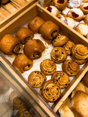 Freshly baked pastries displayed in a wooden box at a bakery, capturing the essence of morning...