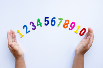 Child hands display colorful numbers 1 to 10 on white background
