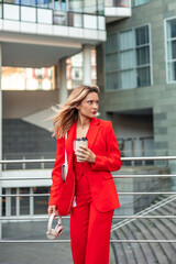 vertical Businesswoman commuting to office holding coffee and headphones