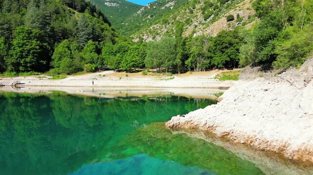 Aerial drone view of Lake San Domenico in the municipality of Villalago in the province of L'Aquila, near the hermitage of San Domenico. Beautiful green hues and peace reign supreme in this place.