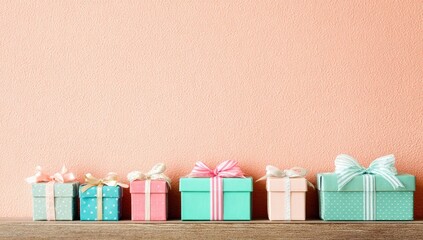 Pastel-colored gift boxes lined up against a peach-toned wall.