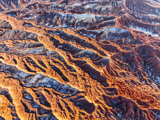 An abstract drone shot reveals the intricate, rippling surface of Mars Canyon's red rock formations...