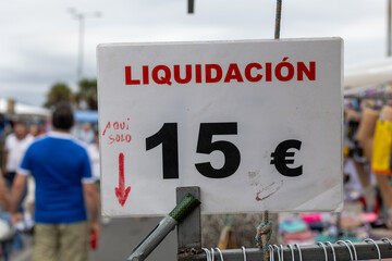 Clearance sale sign displaying 15 euro price at outdoor market