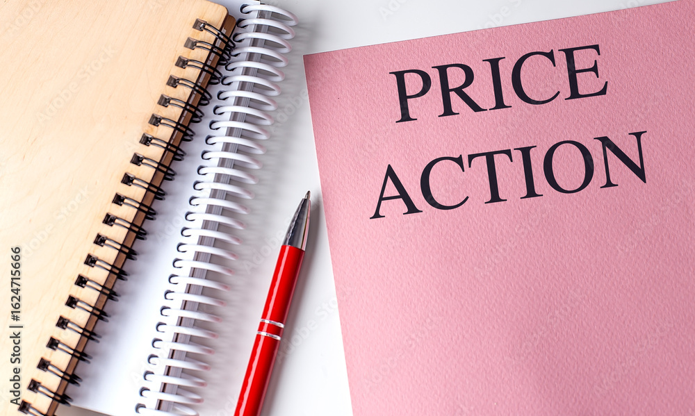 Poster notebook with pink cover showing text price action next to spiral notepad and red pen