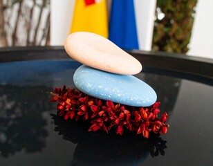 Delicate Stack of Pastel Colored Stones Perfectly Balanced on Calm Dark Water Surface