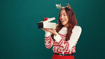 Woman, Christmas and open gift box in studio, thinking and check with mockup space on background....