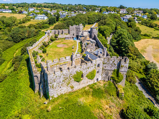 An aerial view looking down towards the old Norman castle ruins at the seaside resort of Manorbier, South Wales in summertime