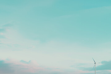 Minimalist landscape with single wind turbine on right side, wide open sky with soft clouds on left for text overlay, calm color palette