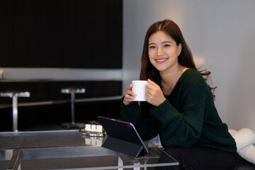 Young woman works at home and drinks hot coffee