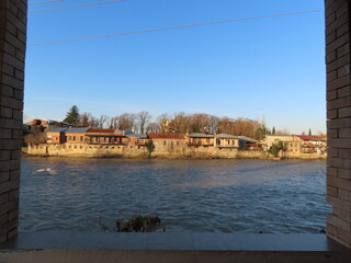 A scenic view of the riverside in Kutaisi, Georgia, featuring the gentle flow of the Rioni River alongside the city's historic charm.