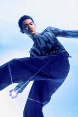 A young Asian male in a stylish outfit posing dynamically.