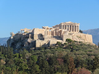 Philopappou Hill in Athens offers panoramic views of the Acropolis, the city skyline, and the Aegean Sea, combining natural beauty with rich historical significance in a peaceful urban park setting.
