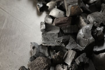 Pieces of black coals on grey table, closeup. Space for text