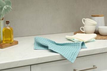 Waffle towels and dishware on white counter near grey wall