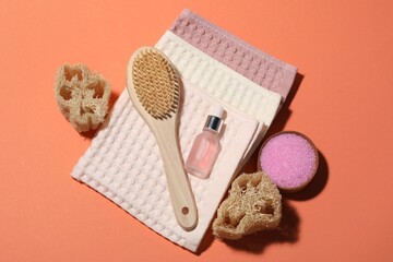 Clean waffle towels and spa products on coral background, flat lay