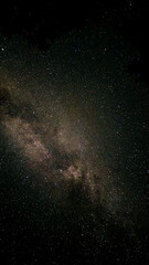 Clear starry sky with scattered stars and constellations visible above the dark horizon, ideal for...