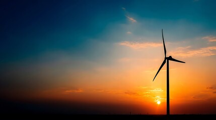 Obraz premium Silhouette of wind turbine against a vibrant sunset sky, generating clean energy