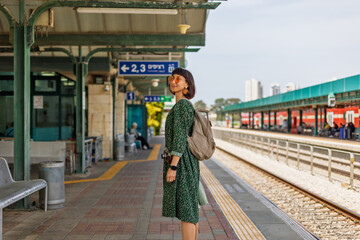 Fototapeta premium girl looking at watch and waiting for train. girl standing at train station waiting for train.