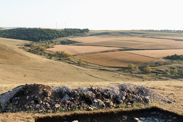 A serene calm landscape featuring rolling hills, scattered rocks, and patches of grass