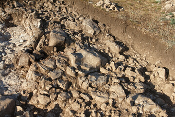Archaeological scientific work excavation site with exposed detailed soil layers and chalky terrain