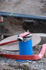 Blue pipe with a red hose on top of it