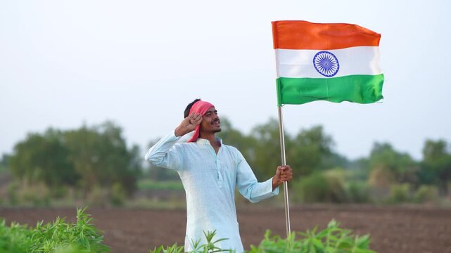 Young indian farmer salute indian flag at agriculture field 