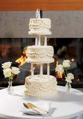 Elegant three-tier wedding cake with bride and groom figurine on top, beautifully decorated for...