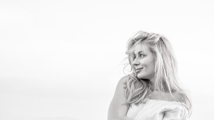 Tender Portrait of a Blonde Girl Looking Away Under Clear Sky