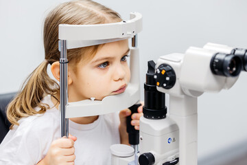 Young girl undergoing vision testing with advanced ophthalmic equipment, focused on eye examination...