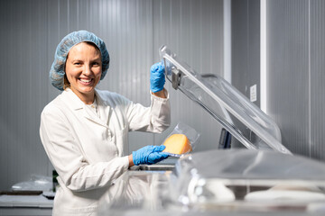 Industrial food packaging machine. Food factory production line worker packing food on vaccuum...