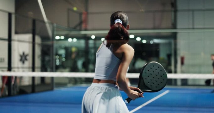 Back, woman and serve with racket for padel games, sports training and practice for competition. Athlete, people and tennis with ball for contest performance, match preparation and fitness tournament