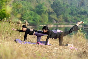 Asian Indonesian Women Doing Yoga Pose by a Peaceful River in Nature